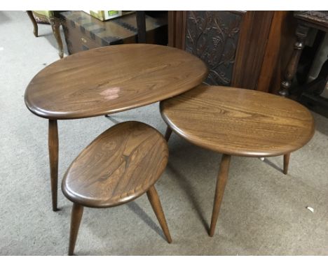 A nest of Ercol pebble tables , damaged top. 40cm tall.