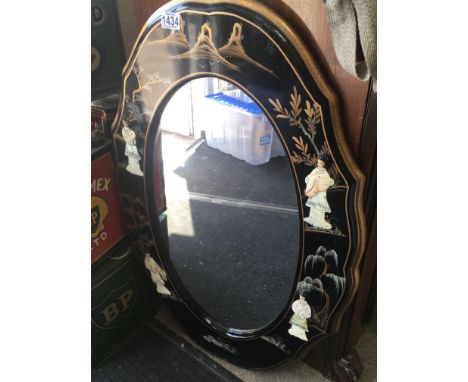 A oval Chinese style wall mirror decorated with raised figures trees and foliage. 50 cm x 90 cm