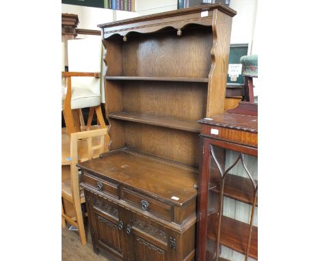 A reproduction oak shelf back dresser