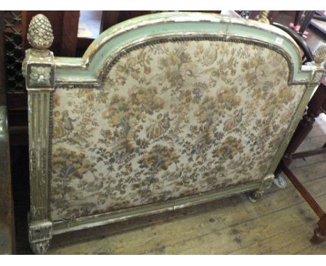 A gilt and painted headboard with tapestry inset and pine cone finials