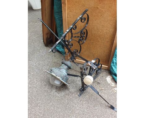 A copper street lamp with two decorative wrought iron brackets