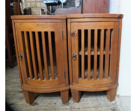 A pair of bow front pine bedside cabinets with slatted doors