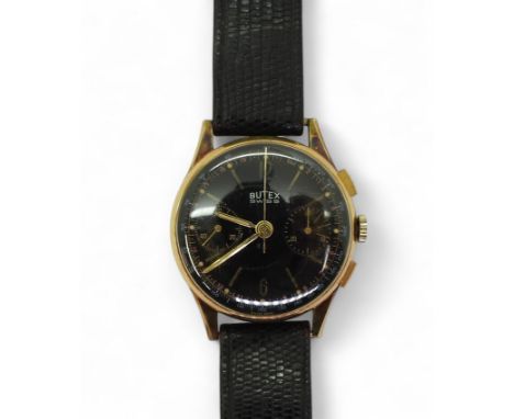 A 14CT BUTEX WATCH with a black dial and twin subsidiary dials, gold coloured baton and Arabic numerals. The case with full S