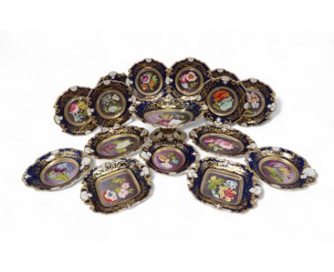 AN ANTIQUE PORCELAIN BOTANICAL DESSERT SERVICE  the cobalt blue banded border with gilded floral decoration and relief moulde