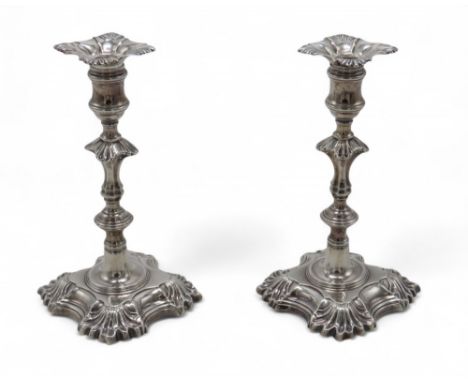 A PAIR OF GEORGE II CAST SILVER CANDLESTICKS by John Cafe, London 1748, with a knopped faceted stem, on quatrefoil bases, wit