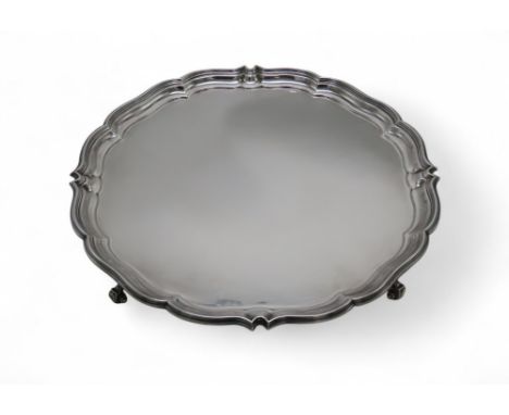 A GEORGE V SILVER SALVER by Harrison Brothers & Howson, London 1911, with a chippendale-style piecrust border, on four scroll