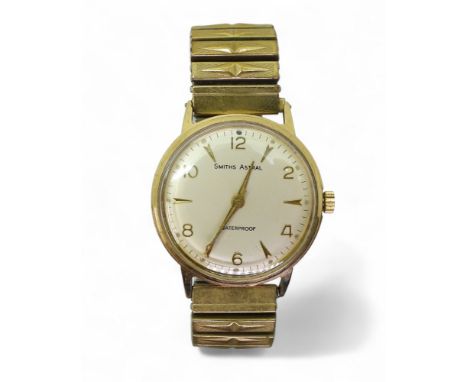 A 9CT GOLD SMITHS ASTRAL WATCH with 17 jewel movement, silvered dial with gold coloured dagger indices and Arabic numerals, a