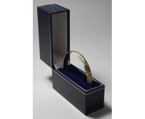A 9CT GOLD BANGLE, with diamond cut detail, hallmarks for London, approximate weight 9 grams