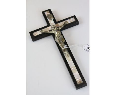 A 20th century wooden and white metal crucifix with mother of pearl inlay.