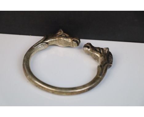 A vintage white metal open ended bangle with horse head decoration, stamped TU.