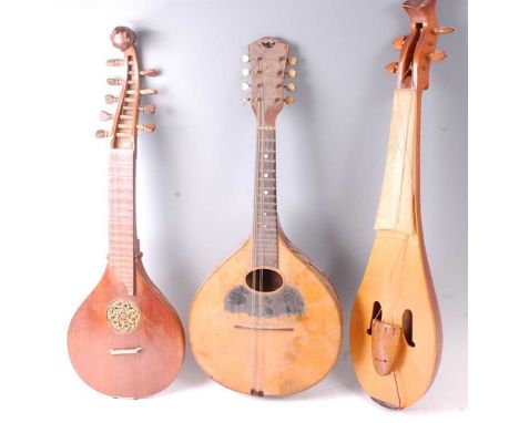 A 20th century cittern, having a pear shaped body with fret carved sound hole, the scroll carved with a jester? figure, havin