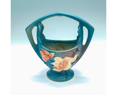 Light blue ceramic basket with Magnolia pattern. Roseville USA backstamp on bottom. Dimensions: 7.5"L x 4.25"W x 7.5"HManufac