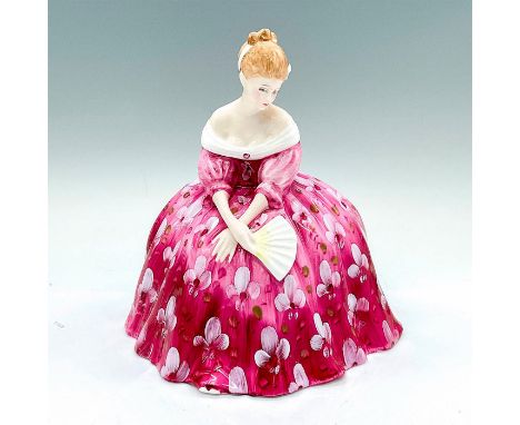 A hand made and hand decorated bone chine figure. Depicts a seated woman in a pink gown with white flowers. Royal Doulton bac