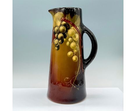 A ceramic brown glazed pitcher with white grapes on a vine that hand painted in relief to the center. ER artist initials. Wel