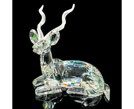Brilliant cut crystal figure of a kudu, a type of antelope, lying down resting, with satin horns. Swarovski etched mark. Item