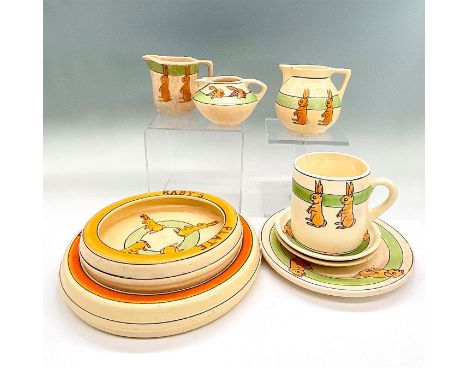 Dishes in a playful rabbit motif. Five plates, three pitchers and one mug. One plate is decorated with dogs. The largest plat
