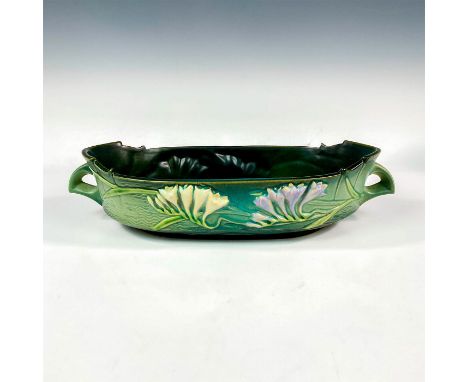 Ceramic handled planter embellished with stylized lavender and white colored flowers that are set against a green textured gr
