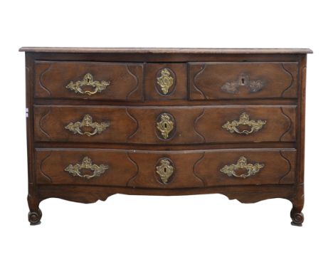 A French provincial serpentine front oak commode, 18th Century, with two short frieze drawers flanking a square drawer, above