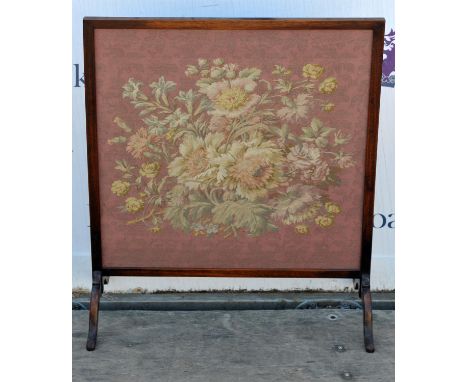 A stained wood fire screen, 20th Century, inset with a tapestry panel of a floral spray on pink textured ground, 85.5cm high 