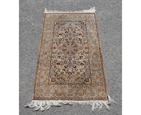 A Kashan design part-silk rug, fawn ground with central rosette and scattered palmettes, 77 x 125 cm. Provenance: From Munste
