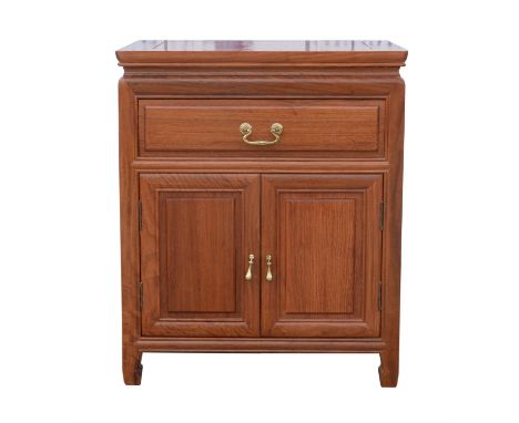 A Chinese hardwood bedside cabinet, 20th Century, with rectangular panelled top, above frieze drawer and two cupboard doors, 