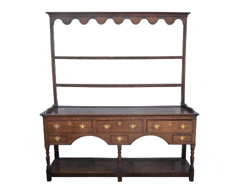 An oak dresser, 19th century, with a two shelf pot rack, the base with rectangular top, above three short and three smaller f