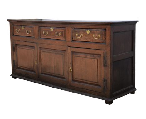 An oak dresser,18th Century, with rectangular top, above three drawers, with two panelled doors, on block feet, 91cm high x 1