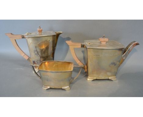 An Art Deco Silver Three Piece Tea Service comprising teapot, hot water pot and two handled sucrier of stylised form, Sheffie