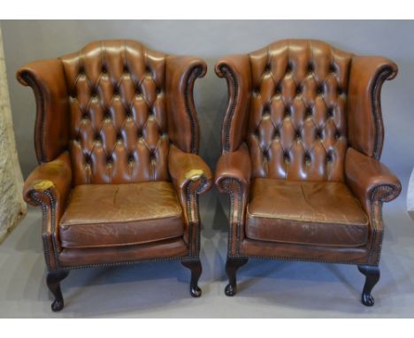 A Pair of Brown Leather Button Upholstered and Brass Studded Wingback Armchairs