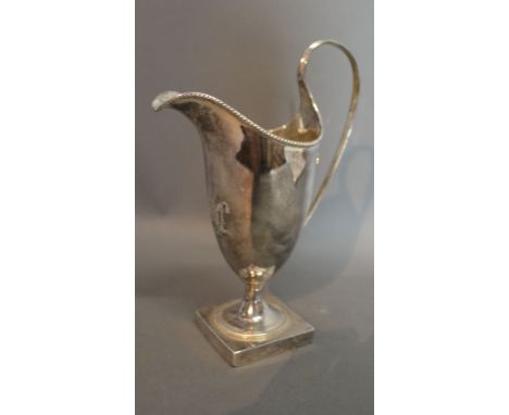 A George III Silver Helmet Shaped Cream Jug with shaped handle and square pedestal base, London 1785, 6 ozs