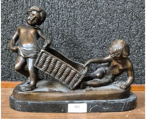 A bronze figure of two putti with basket, on black marble socle