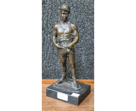 A bronze figure of a miner, on black marble socle