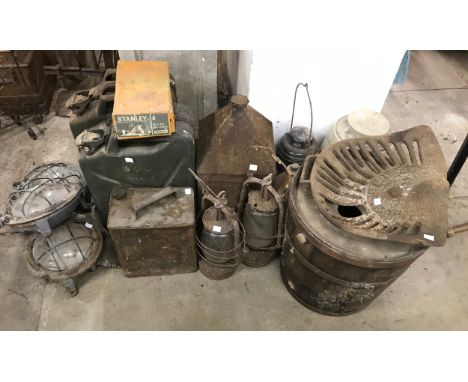 Two jerry cans, three industrial light fittings, three oil lamps and a vintage tractor seat