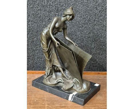 An Art Nouveau style bronze figure of a lady with folio, on black marble socle