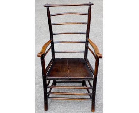 A 19th Century elm seated ladder back open armchair, of regional design, the back with six turned rods to back, solid seat, s