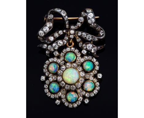 An Edwardian silver and gold, opal and diamond brooch, the bow brooch set with old mixed cut diamonds suspending an opal and 