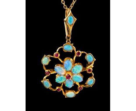 An Edwardian opal and ruby gold brooch/ pendant, set in 15ct gold, comprising an open work daisy set pendant with oval opals,