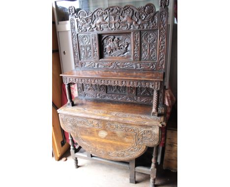 A 17th Century and later oak buffet, the base section originally a gateleg table, the upper section carved throughout with an