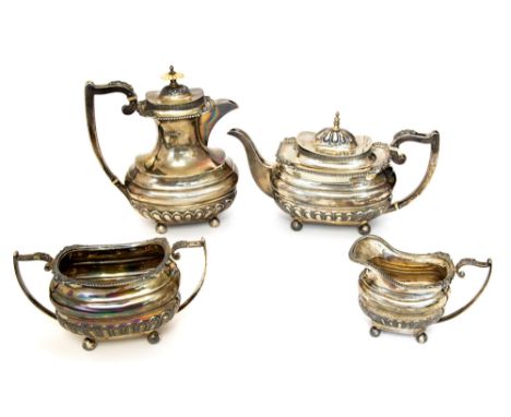 A George V silver four ogee shaped piece tea set, the teapot and hot water jug with hinged covers above guilloche border, the