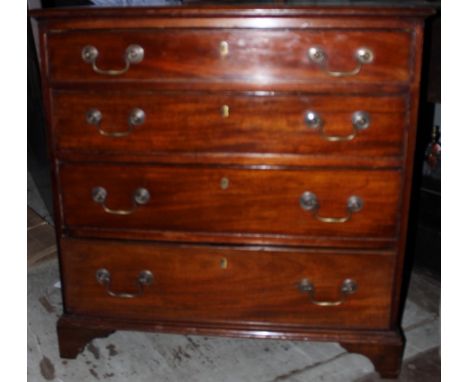 A George III mahogany chest of drawers, having a cross-banded top, comprising four long graduated drawers, all retaining orig
