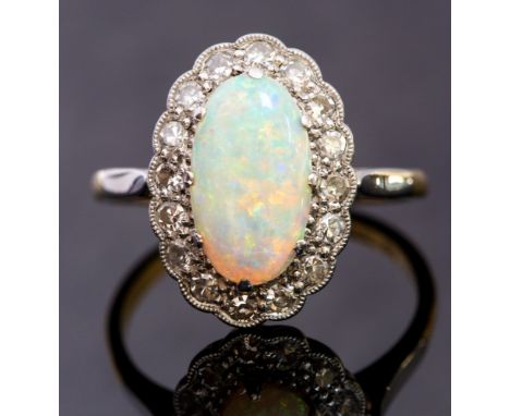 An opal and diamond oval cluster ring, claw set with an elongated oval opal, size approximately 11mm x 7mm, green/orange play