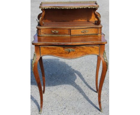 A 19th Century Louis XVI style French bonheur-du-jour, the upper section with a brass gallery edge, raised shelf section on s