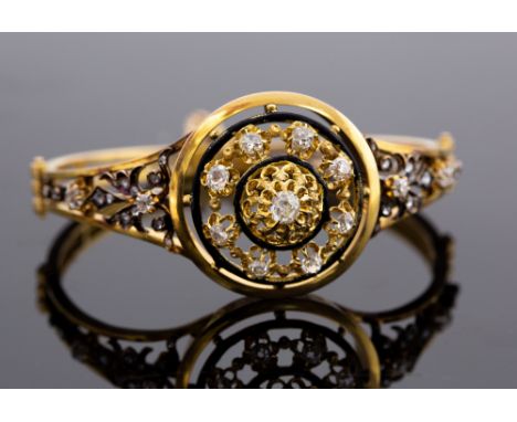 A Victorian gold and diamond hinged bangle, unmarked 18ct, comprising a circular domed head set with old cut diamonds, black 