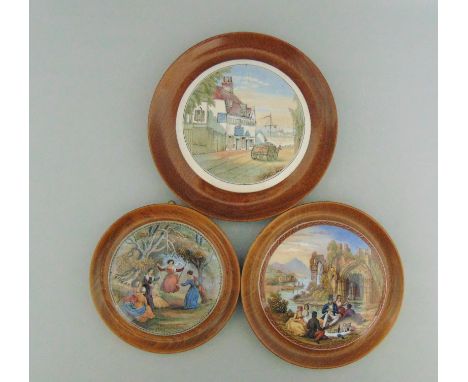 Three Staffordshire Prattware  polychrome pot lids,  mounted in light wooden frames, titled  'The Swings', 'The Picnic' and '