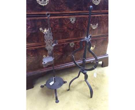 A late 16th/early 17th Century iron trivet; together with a reed/fallow lamp, early 18th Century (2) 