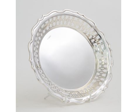 A George V silver dish, the wavy rim above gallery pierced with geometric design, plain centre on three scroll feet, Sibray, 