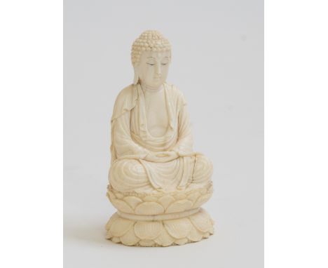 An Oriental ivory model of a buddha, late 19th/early 20th Century, wearing a headdress and seated cross legged on a lotus lea