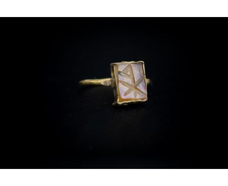 Byzantine (7th-9th century AD) A gold ring with twisted wire band; rectangular collar to the bezel set with a glass intaglio 