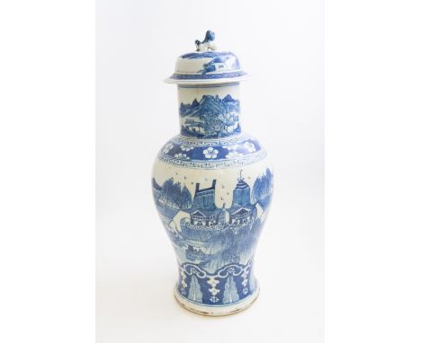 A Chinese blue and white jar and cover, Kangxi style, lakeside temple scene with figures, above a a ruyi lappet border, 50cm 