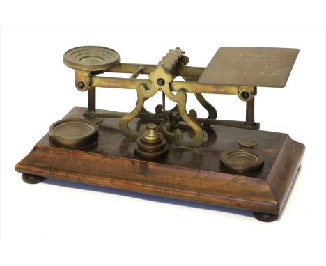 A set of brass postal scales, by Sampson Mordan &amp; Co., late 19th century, a walnut base supporting six weights, the beam 